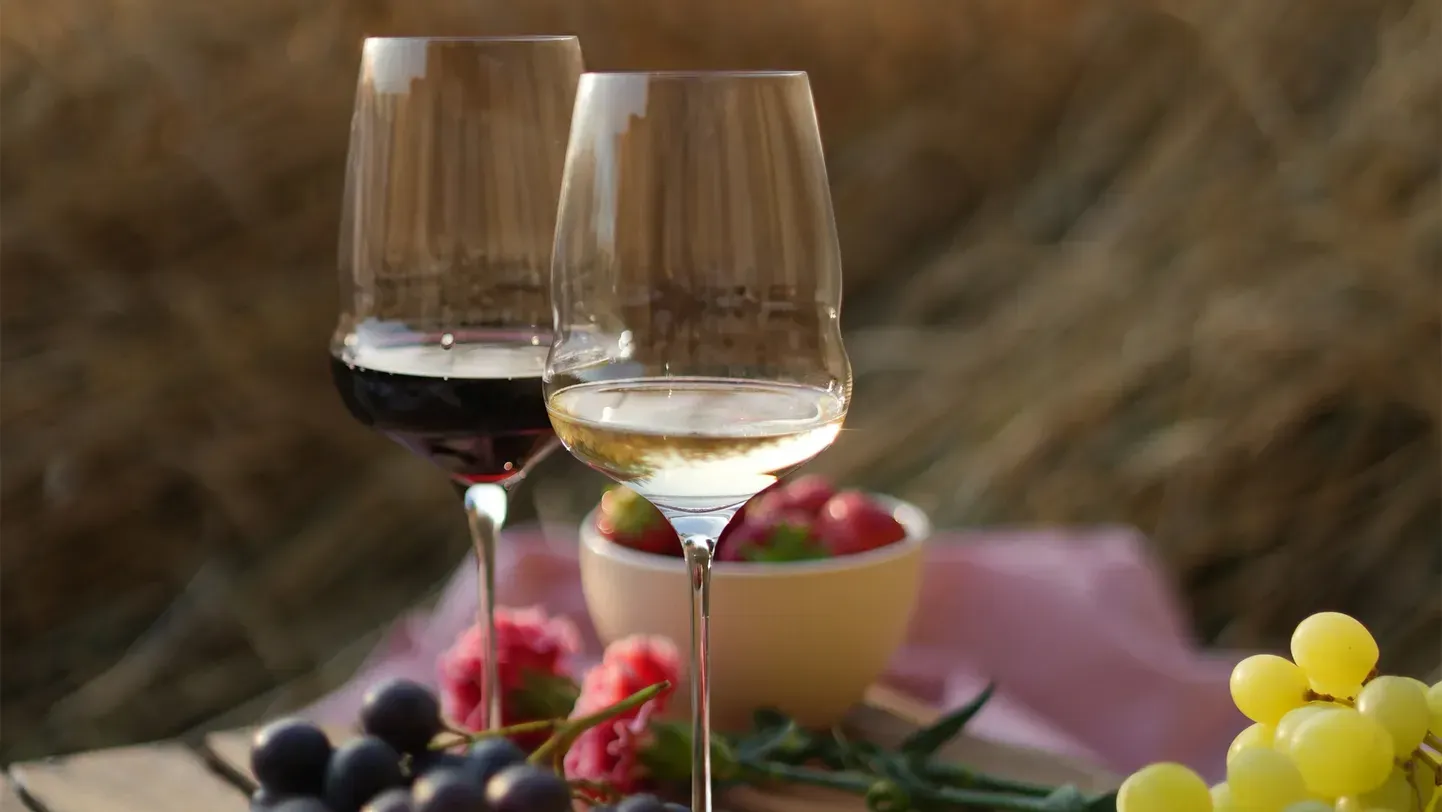 Red and white wine glasses on a table set outdoors